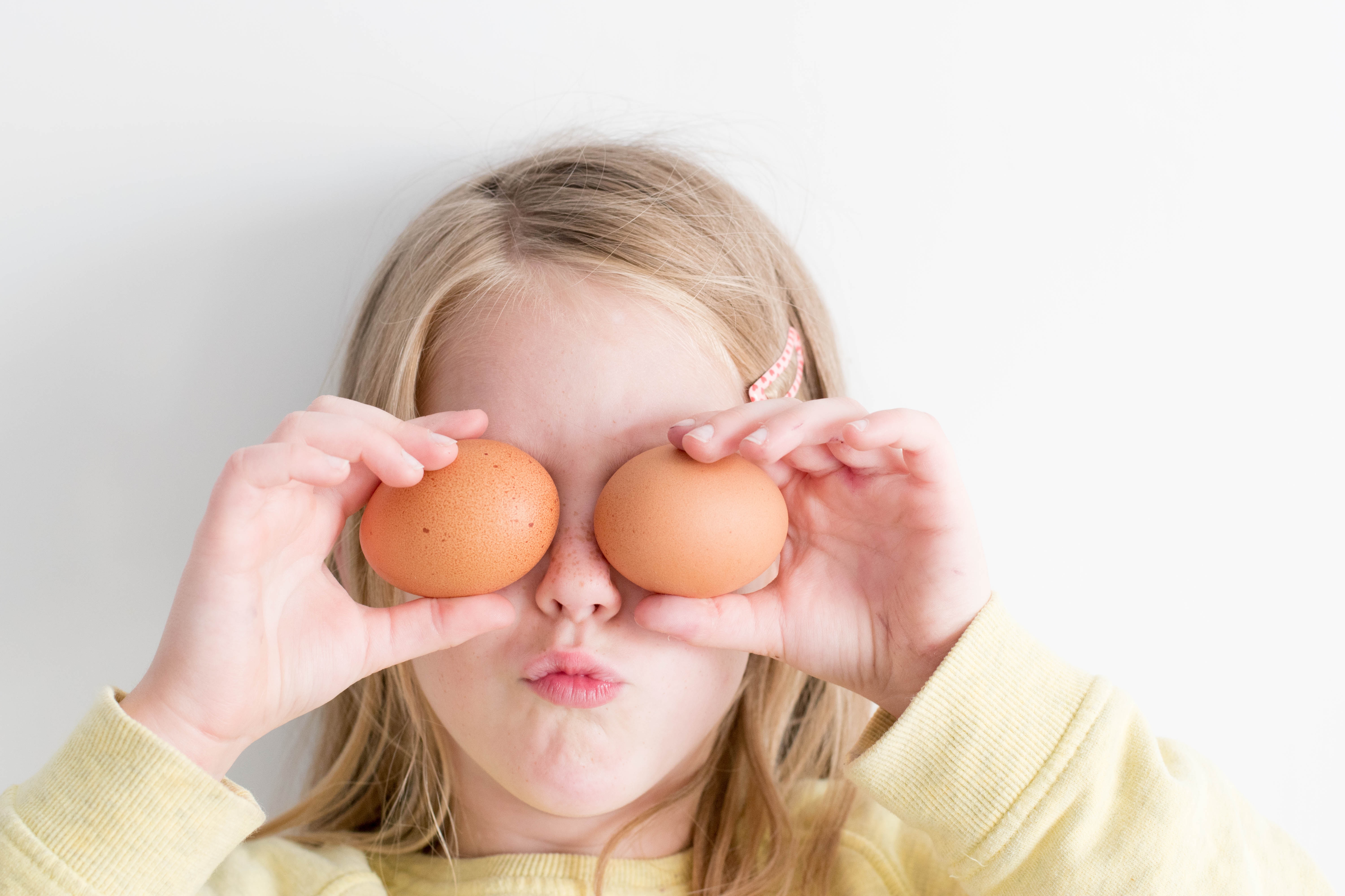 Girl holding boiled eggs of eyes